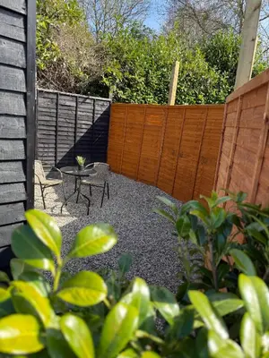 a backyard with a fence and a table and chairs at Colne cabin in Earls Colne