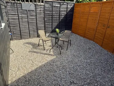 a patio with a table and chairs and a fence at Colne cabin in Earls Colne