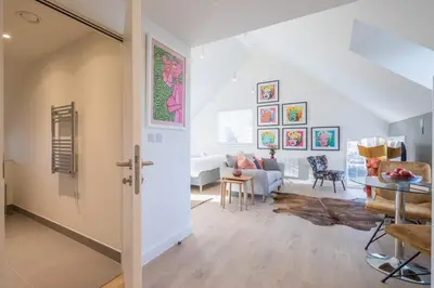 a living room with a table and a couch at Beautiful Central Apt With Parking in Cambridge