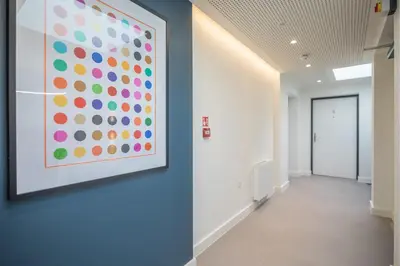an office hallway with a large painting on the wall at Beautiful Central Apt With Parking in Cambridge