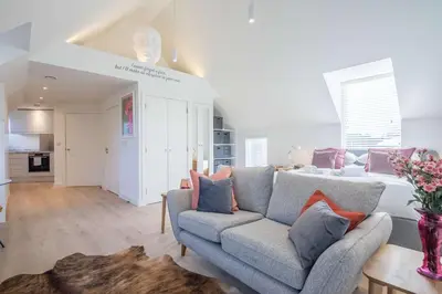 a living room with a couch and a bed at Beautiful Central Apt With Parking in Cambridge
