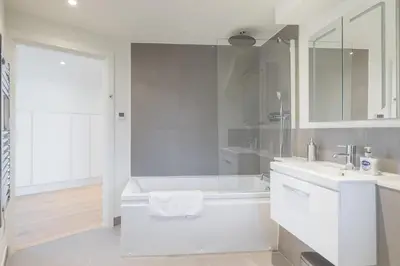 a white bathroom with a tub and a sink at Beautiful Central Apt With Parking in Cambridge