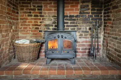 a wood stove in a brick wall at Willow Cottage in Saxtead