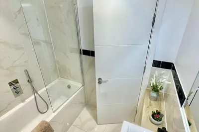a bathroom with a shower and a tub and a toilet at 3 Bed Flat - Sleeps 6 - Parking - Wifi in Cambridge