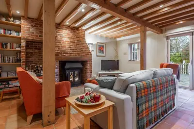 a living room with a couch and a fireplace at The Granary, Hacheston 4 in Marlesford