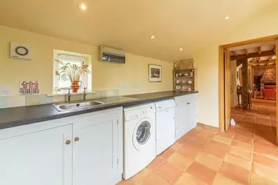 a kitchen with a sink and a washing machine at The Granary, Hacheston 4 in Marlesford
