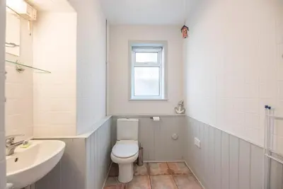 a white bathroom with a toilet and a sink at Milestone House, Aldeburgh in Aldeburgh
