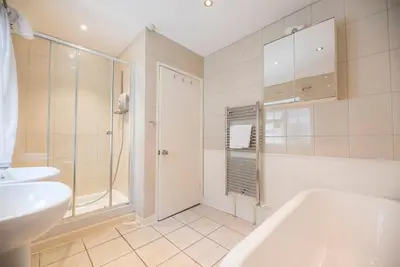a bathroom with a tub and a sink and a shower at Milestone House, Aldeburgh in Aldeburgh