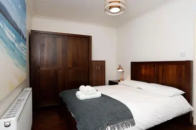 a bedroom with a bed with two towels on it at Charming 2-Bedroom Maisonette in Leigh-on-Sea