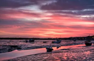 a sunset over a body of water with boats at Charming 2-Bedroom Maisonette in Leigh-on-Sea