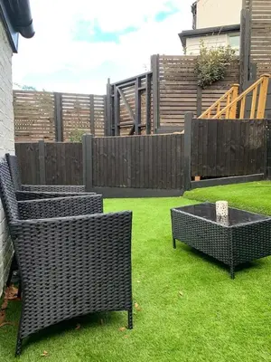two wicker chairs and a table in a yard at Charming 2-Bedroom Maisonette in Leigh-on-Sea