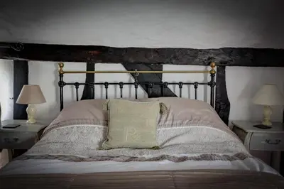 a bedroom with a bed and two tables with lamps at Willow cottage in Saxtead