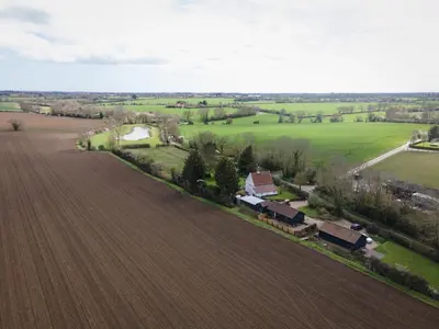 an aerial view of a field and a farm at Willow cottage in Saxtead