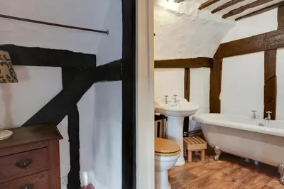 a bathroom with a tub toilet and a sink at Willow cottage in Saxtead