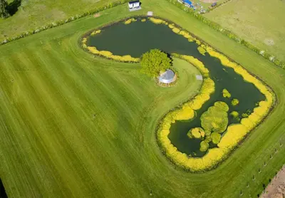 an overhead view of a golf course with a pond at The Shepherds Hut at Anvil House in Woodbridge