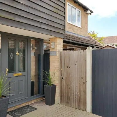 a house with a grey door and a fence at Brandeston Close in Great Waldingfield