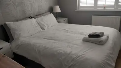 a white bed with a towel on top of it at Brandeston Close in Great Waldingfield