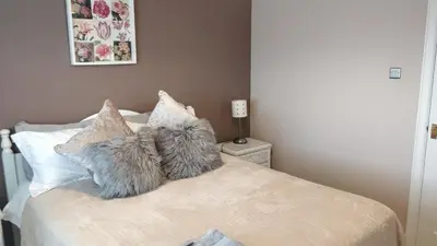 a bedroom with a bed with two furry pillows at Brandeston Close in Great Waldingfield