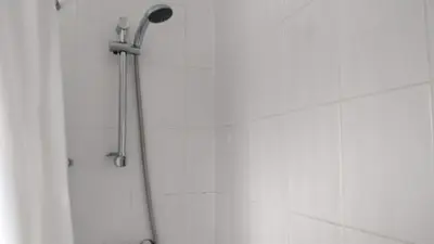 a shower with a shower head in a bathroom at Brandeston Close in Great Waldingfield