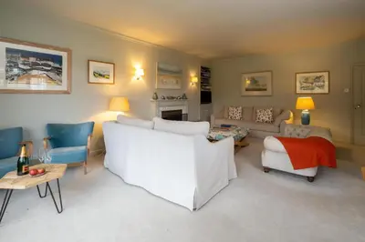 a living room with a white couch and chairs at 3 The Coastguards, Thorpeness - Only a stones throw from the Beach and very close to famous boating Meare, Country Club and Golf Club - Aldeburgh Coastal Cottages in Thorpeness