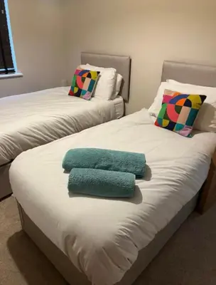 two beds with towels on top of them in a room at Leigh On Sea -Broadway-Two Bed with Garden in Southend-on-Sea