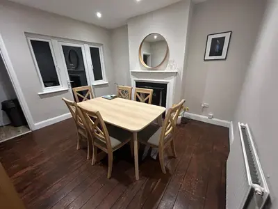 a dining room with a table and chairs and a fireplace at Leigh On Sea -Broadway-Two Bed with Garden in Southend-on-Sea