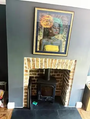 a fireplace with a picture of a woman on the wall at Leigh On Sea -Broadway-Two Bed with Garden in Southend-on-Sea