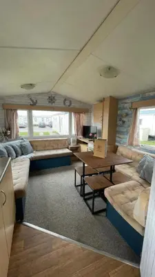 a living room with a couch and a table at Adventure Van 6 berth St Osyth Beach Park in Saint Osyth