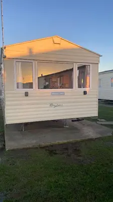 a white rv is parked in a yard at Adventure Van 6 berth St Osyth Beach Park in Saint Osyth