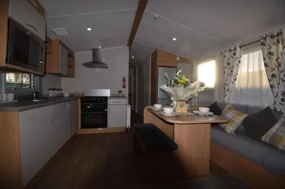 a kitchen and living room with a couch and a table at 25 Poplars Way Walton on Naze in Walton-on-the-Naze