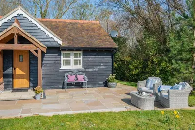a small house with a patio with two chairs at The Gate Lodge - Pet Free - Near Finchingfield & Saffron Walden in Great Sampford