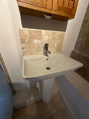 a white sink in a bathroom with a counter at character filled barn renovation in Old Hurst