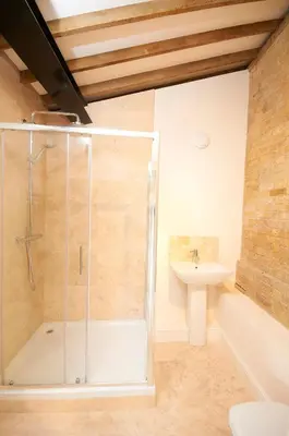 a bathroom with a shower and a sink at character filled barn renovation in Old Hurst