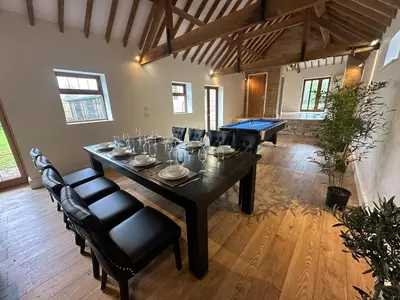 a large dining room with a table and chairs at character filled barn renovation in Old Hurst