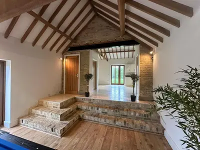 a living room with a stone staircase in a house at character filled barn renovation in Old Hurst