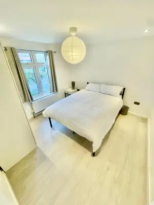 a bedroom with a white bed and a window at 2 Bed Flat - Sleeps 5 - Parking - Wifi in Cambridge