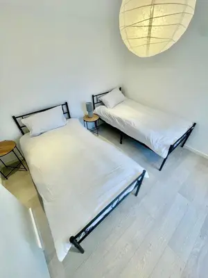 two twin beds in a room with a chandelier at 2 Bed Flat - Sleeps 5 - Parking - Wifi in Cambridge