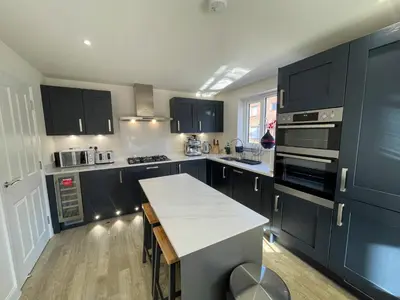 a kitchen with black cabinets and a white counter top at Brand new prestigious house near science park in Cambridge
