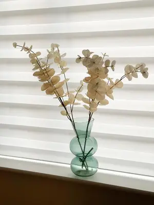 a vase with flowers sitting on a window sill at Brand new prestigious house near science park in Cambridge