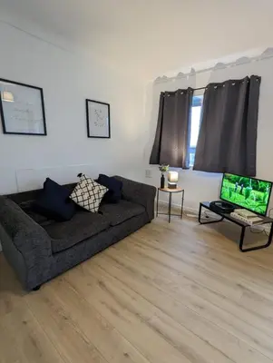 a living room with a couch and a laptop at Chic Colchester Flat in Colchester