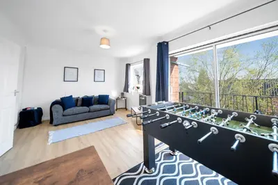 a living room with a couch and a large window at Chic Colchester Flat in Colchester