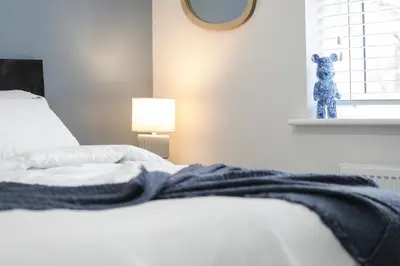 a bedroom with a bed with a teddy bear on the window at Suffolk 3-BR Coastal House Aldeburgh & Thorpeness in Aldringham