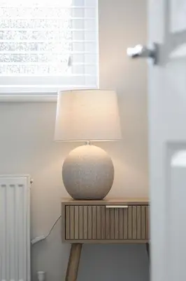 a lamp sitting on top of a wooden table at Suffolk 3-BR Coastal House Aldeburgh & Thorpeness in Aldringham