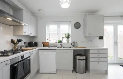 a white kitchen with white cabinets and a sink at Suffolk 3-BR Coastal House Aldeburgh & Thorpeness in Aldringham
