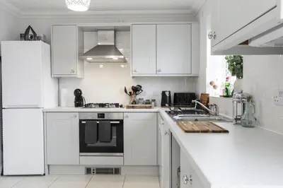 a kitchen with white cabinets and a black and white appliance at Suffolk 3-BR Coastal House Aldeburgh & Thorpeness in Aldringham