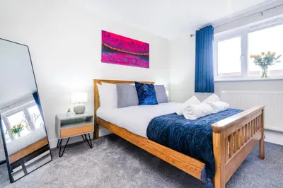 a bedroom with a bed and a mirror at 2 Bed Elegant home with Parking in Harlow in Harlow