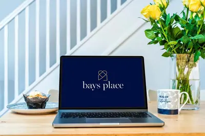 a laptop computer sitting on a table with flowers at 2 Bed Elegant home with Parking in Harlow in Harlow