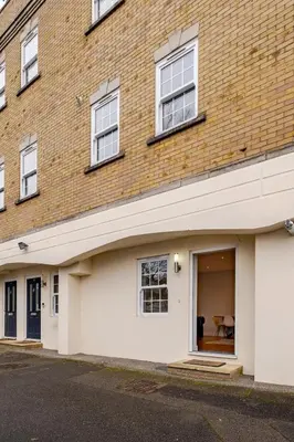 a brick building with a white garage at Lovely Central Brentwood Flat in Brentwood