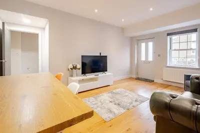 a living room with a table and a television at Lovely Central Brentwood Flat in Brentwood