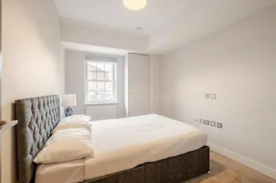 a white bedroom with a large bed in it at Lovely Central Brentwood Flat in Brentwood